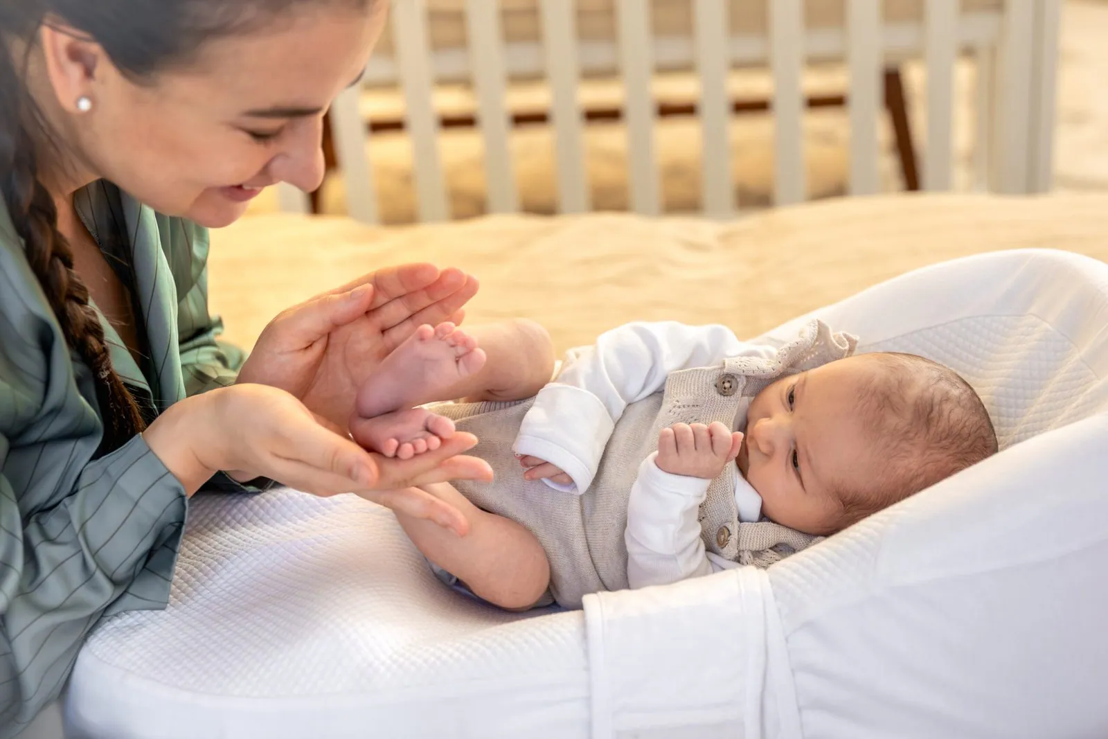 Les mans d'una cuidadora aguanten els peus d'un bebè acabat de néixer